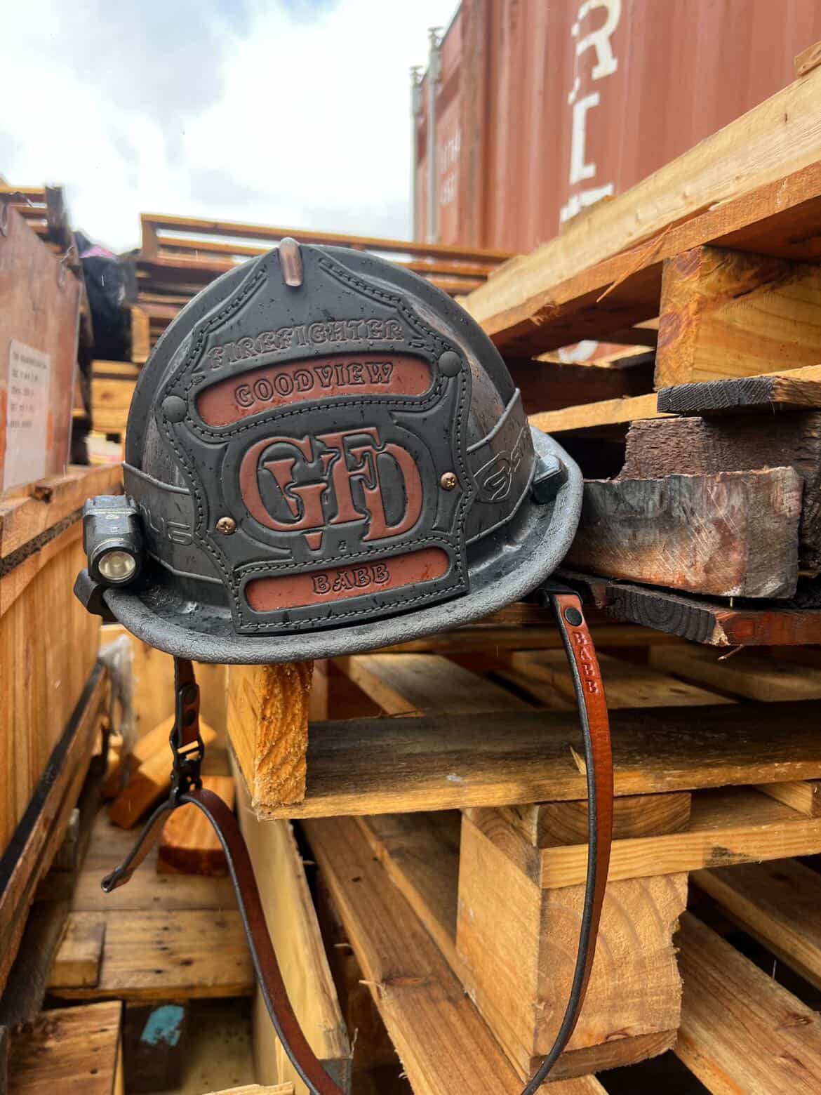 Fire helmet with 'Goodview' logo on a wooden pallet