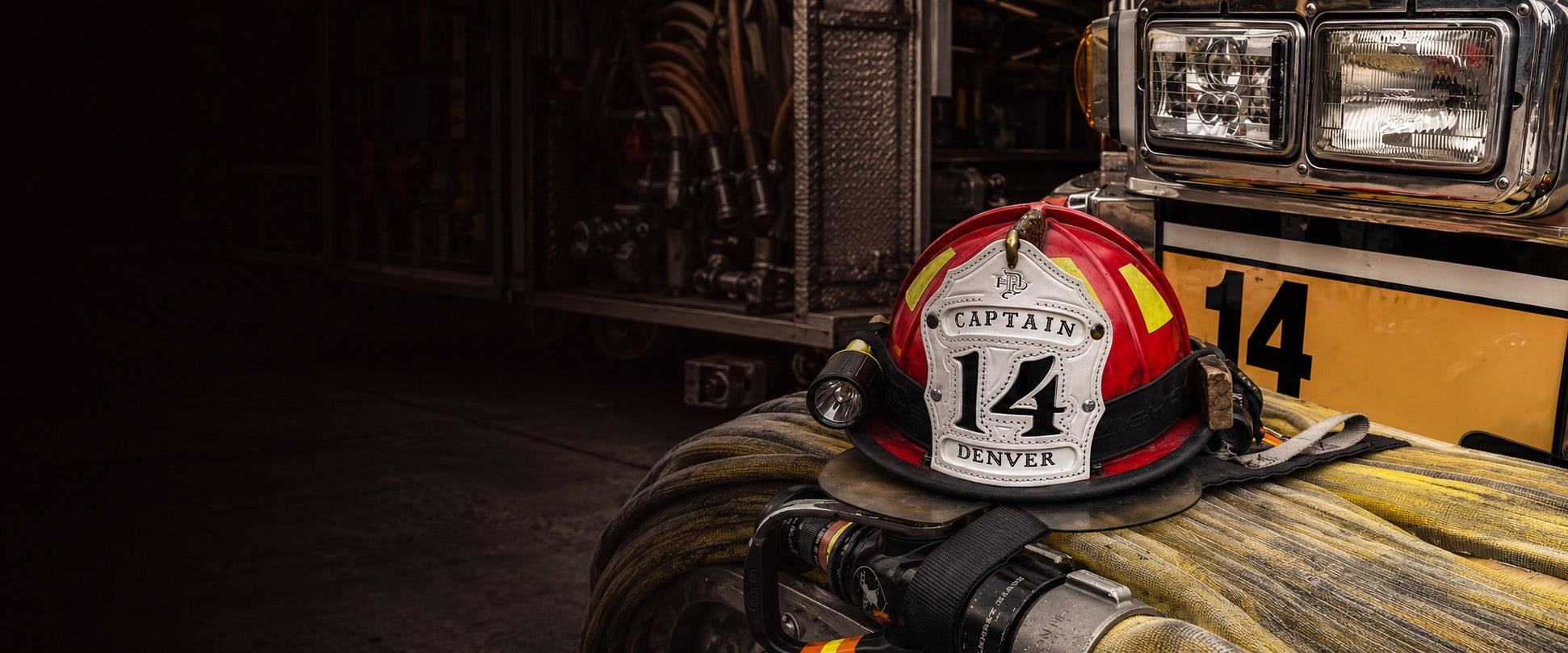 Firefighter helmet with 'Captain 14' and 'Denver' on a fire truck background