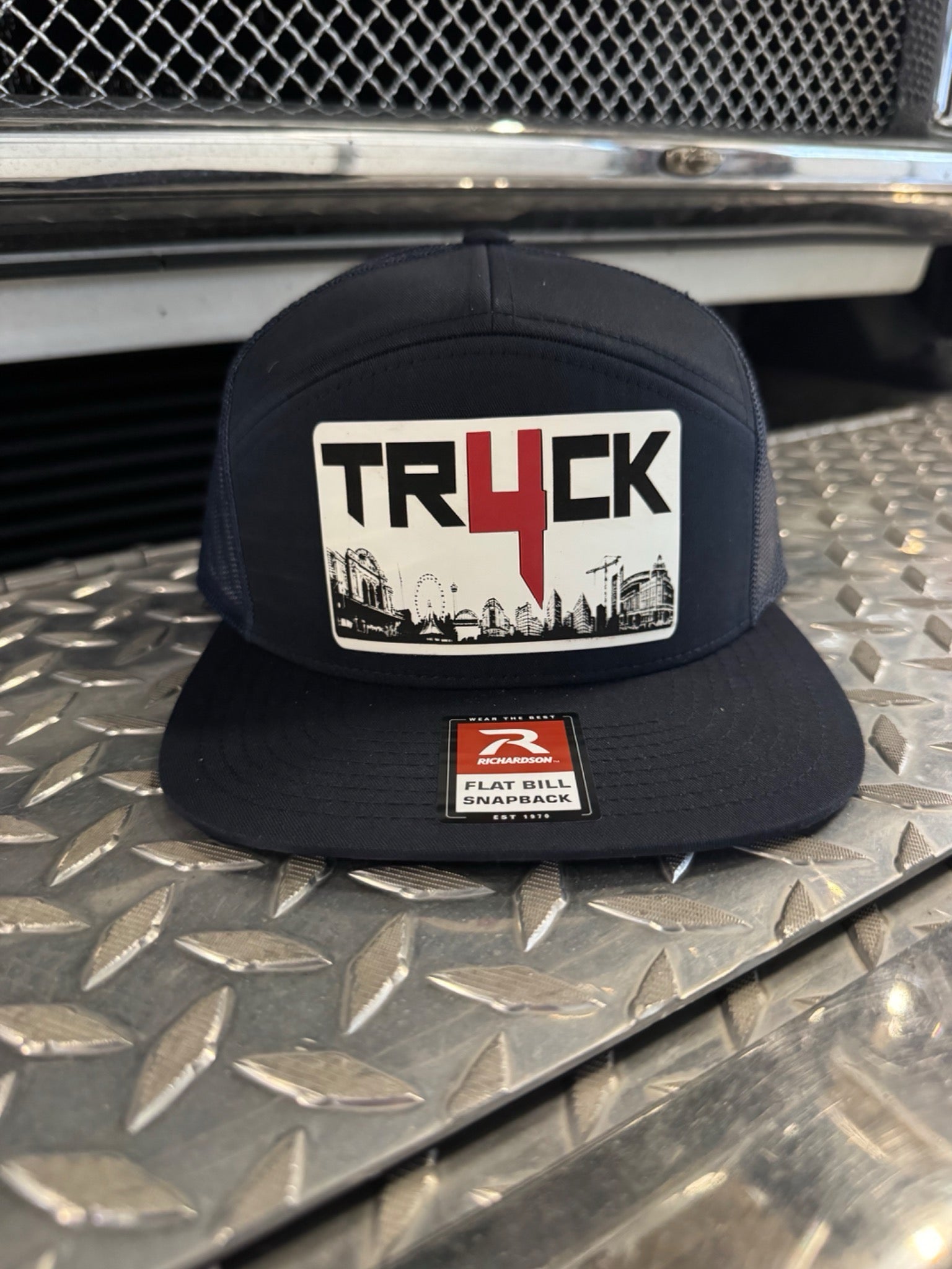 Navy cap with 'TRUCK' logo on a metallic surface